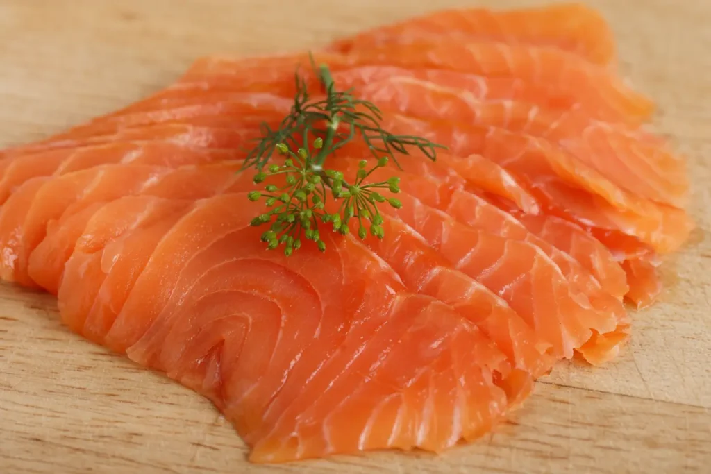 Finished smoked salmon sliced on a wooden board